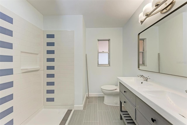 bathroom featuring toilet, vanity, and walk in shower