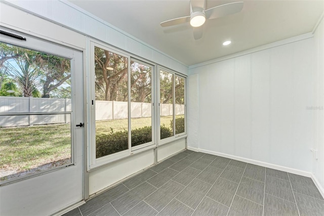 unfurnished sunroom with ceiling fan