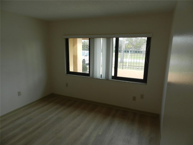 unfurnished room with wood finished floors and baseboards