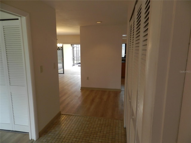 corridor featuring baseboards and wood finished floors