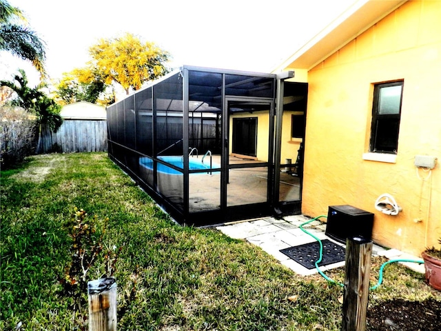 exterior space featuring a fenced in pool, a lanai, a patio area, and a lawn