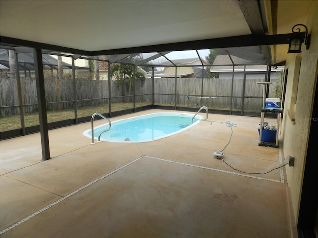 view of pool with glass enclosure, fence, and a patio