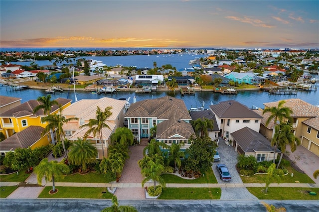 aerial view at dusk featuring a water view