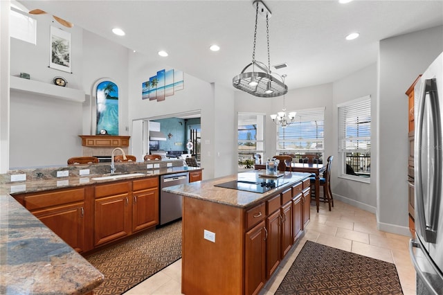 kitchen with light tile patterned floors, stainless steel appliances, sink, and a center island