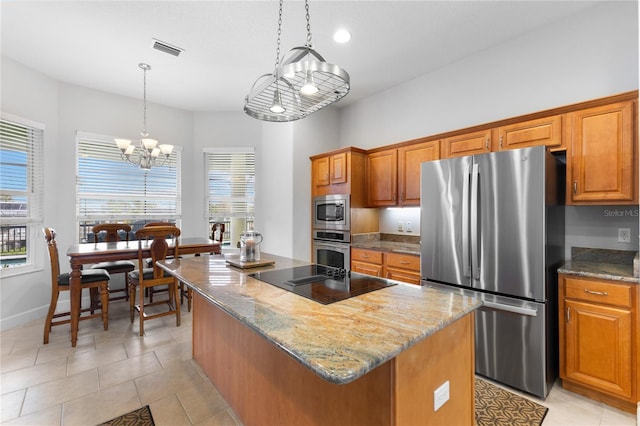 kitchen with decorative light fixtures, a center island with sink, appliances with stainless steel finishes, light stone counters, and a chandelier