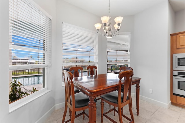 dining room with plenty of natural light, light tile patterned floors, and a notable chandelier