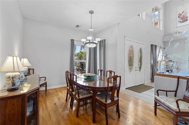 dining space with an inviting chandelier and light hardwood / wood-style flooring