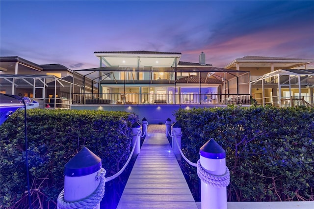 back house at dusk featuring a lanai