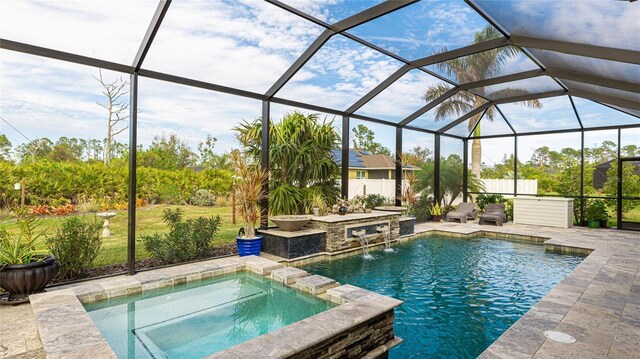 view of pool with pool water feature, glass enclosure, an in ground hot tub, and a patio area