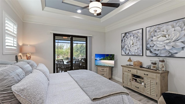 bedroom with access to exterior, ceiling fan, ornamental molding, light hardwood / wood-style flooring, and a tray ceiling