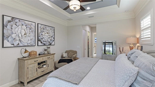 bedroom featuring ornamental molding, a raised ceiling, ceiling fan, and light hardwood / wood-style flooring