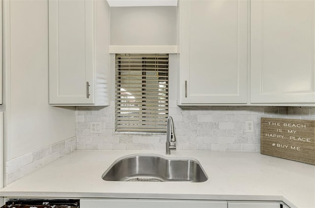 kitchen featuring white cabinets, backsplash, sink, and dishwashing machine