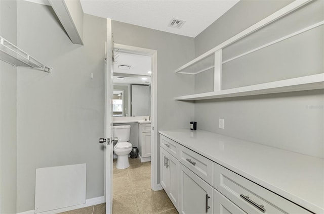 bathroom featuring toilet, tile patterned floors, and vanity