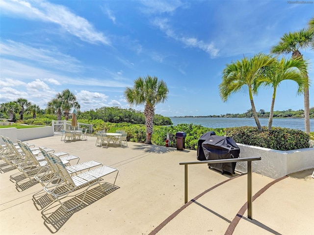 view of patio with a grill and a water view