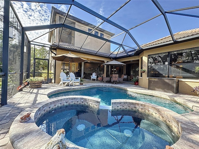 view of pool with an in ground hot tub, a lanai, and a patio area