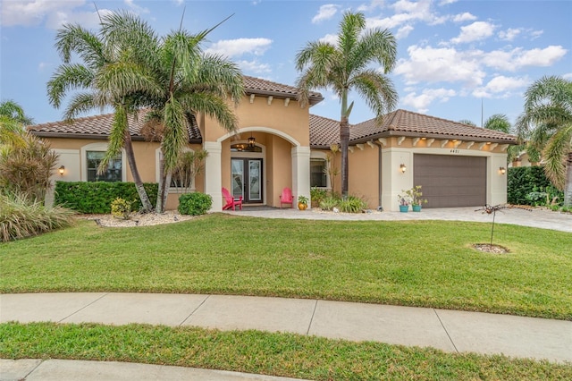 mediterranean / spanish house with a garage and a front lawn