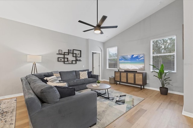 living room with ceiling fan, high vaulted ceiling, light hardwood / wood-style flooring, and a wealth of natural light