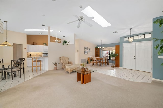 carpeted living room featuring ceiling fan, high vaulted ceiling, and a skylight