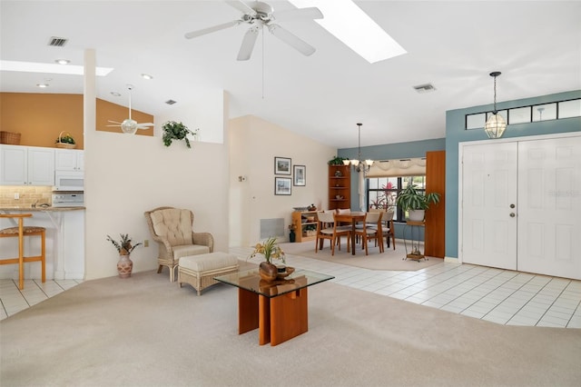 interior space with ceiling fan with notable chandelier and vaulted ceiling with skylight