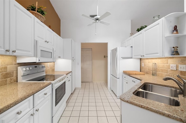 kitchen with white appliances, white cabinets, sink, backsplash, and light stone counters