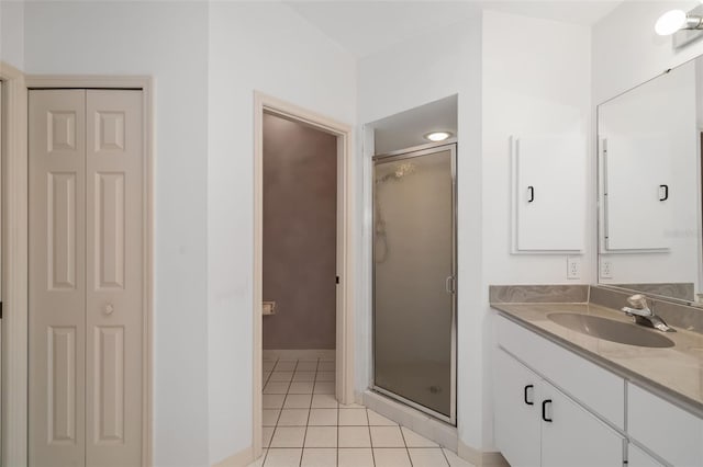 bathroom with walk in shower, vanity, and tile patterned floors