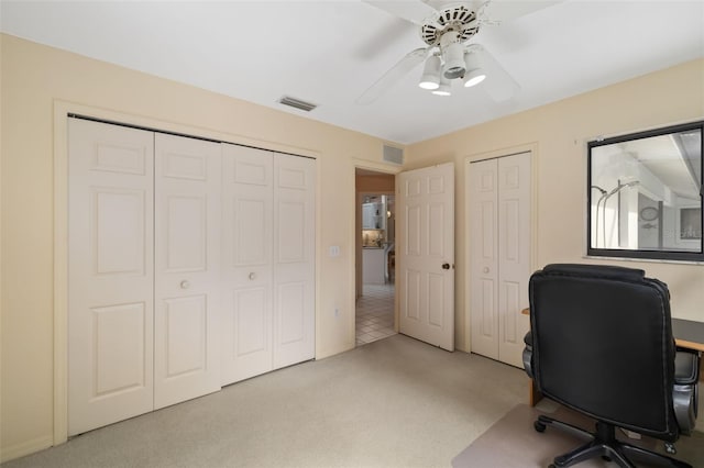 carpeted home office with ceiling fan