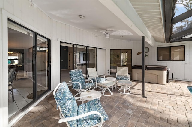 view of patio / terrace with ceiling fan and a hot tub