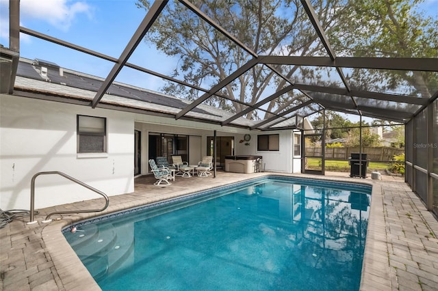 view of swimming pool with a patio area, a lanai, a hot tub, and area for grilling