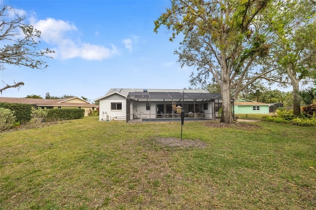 back of property featuring a lanai and a lawn