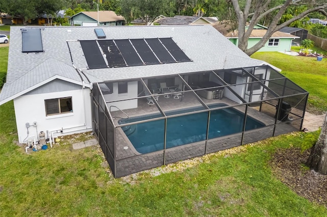 back of house with a lawn, a patio area, solar panels, and glass enclosure