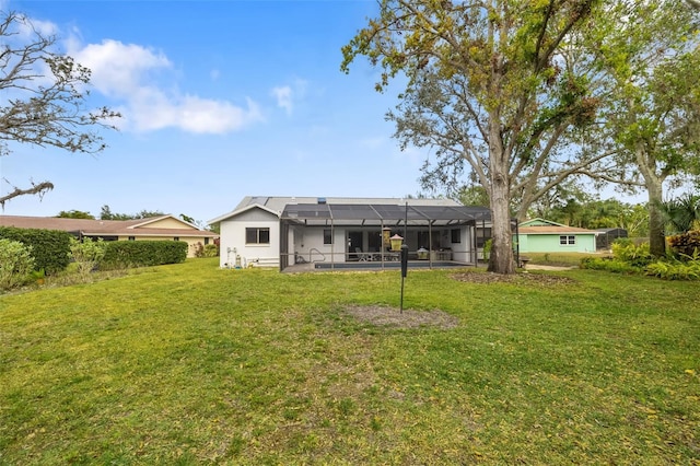 back of house with a lanai and a lawn