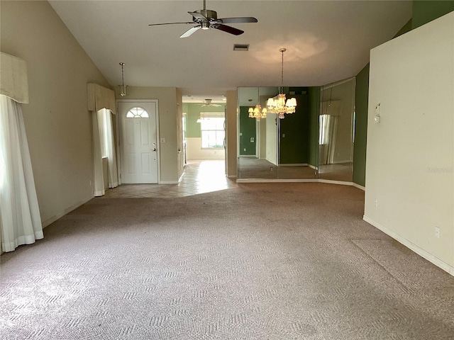 interior space featuring light colored carpet, vaulted ceiling, and ceiling fan with notable chandelier