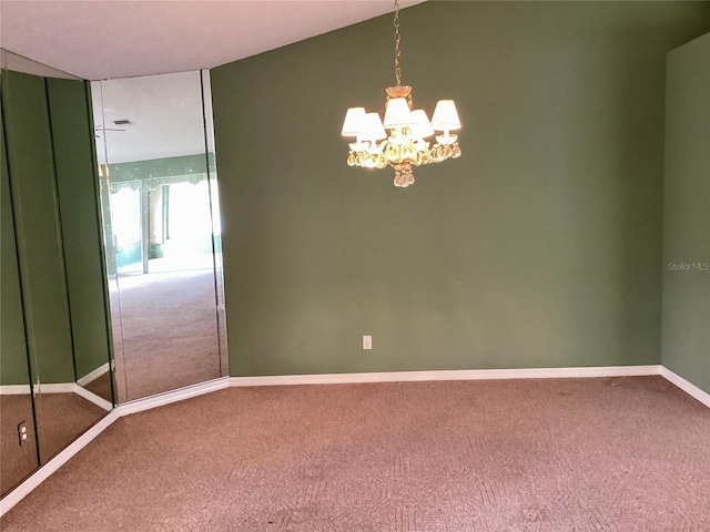 carpeted spare room with a notable chandelier