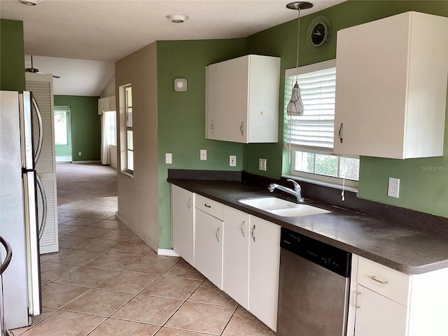 kitchen with vaulted ceiling, white cabinets, fridge, stainless steel dishwasher, and sink