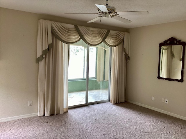 carpeted empty room with a textured ceiling and ceiling fan