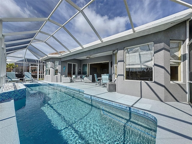 view of swimming pool featuring ceiling fan, a lanai, and a patio