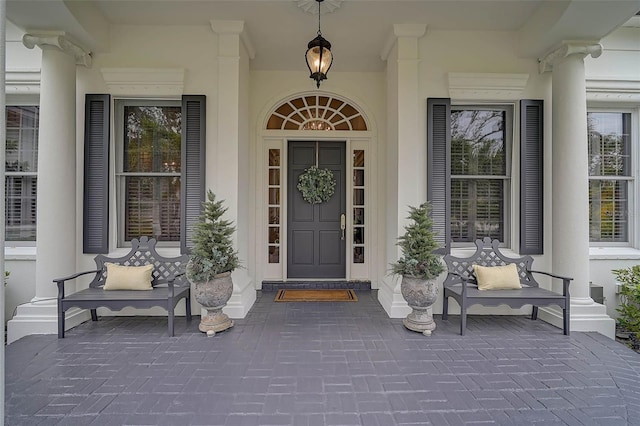 property entrance with a porch and stucco siding