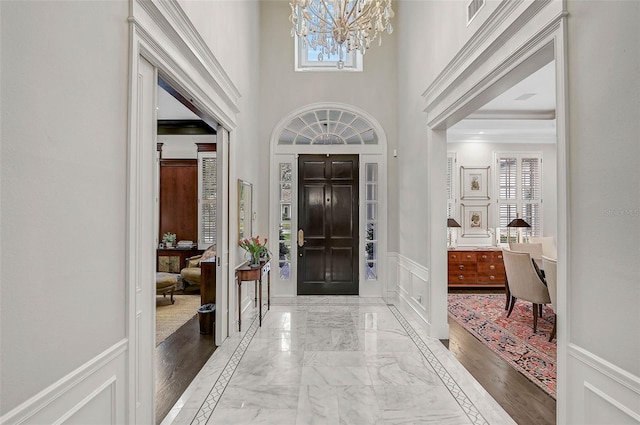 foyer with visible vents, marble finish floor, a healthy amount of sunlight, and a decorative wall