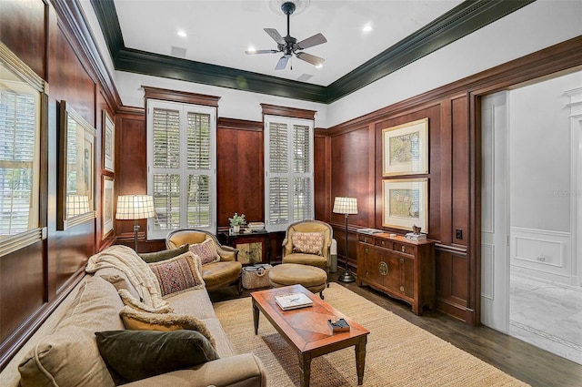 interior space featuring ceiling fan, ornamental molding, dark wood-style flooring, and a decorative wall