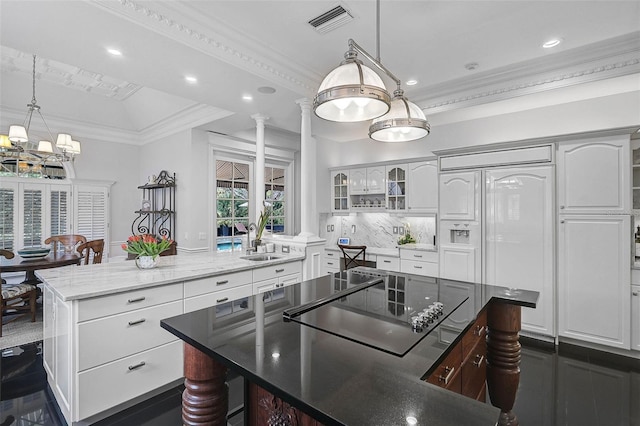 kitchen with visible vents, a center island, glass insert cabinets, crown molding, and black electric cooktop