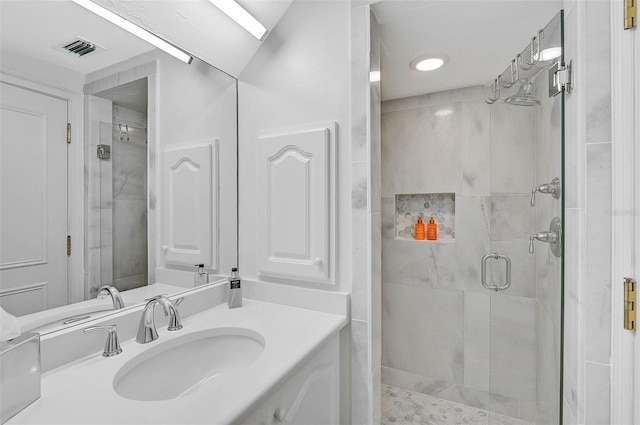 full bathroom with visible vents, vanity, and a shower stall