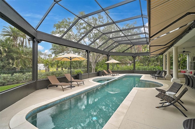 view of swimming pool with glass enclosure, a patio, a ceiling fan, and a pool with connected hot tub