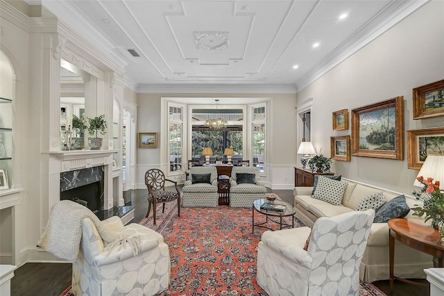 living room with visible vents, a chandelier, a premium fireplace, ornamental molding, and recessed lighting