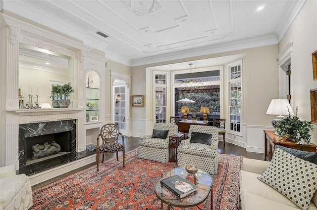 living room with dark wood finished floors, visible vents, a fireplace, and ornamental molding