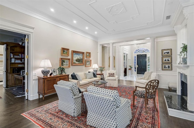 living area featuring decorative columns, a high end fireplace, ornamental molding, and dark wood-style flooring