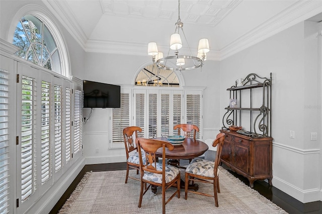 dining room featuring baseboards, crown molding, an inviting chandelier, and wood finished floors