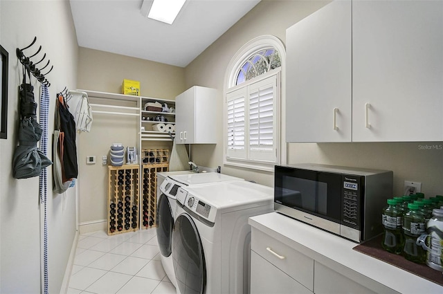 laundry area featuring cabinet space, light tile patterned floors, and separate washer and dryer