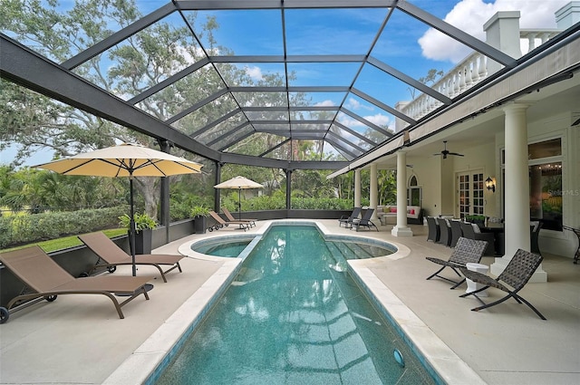 pool featuring a patio area, an outdoor living space, glass enclosure, and a ceiling fan