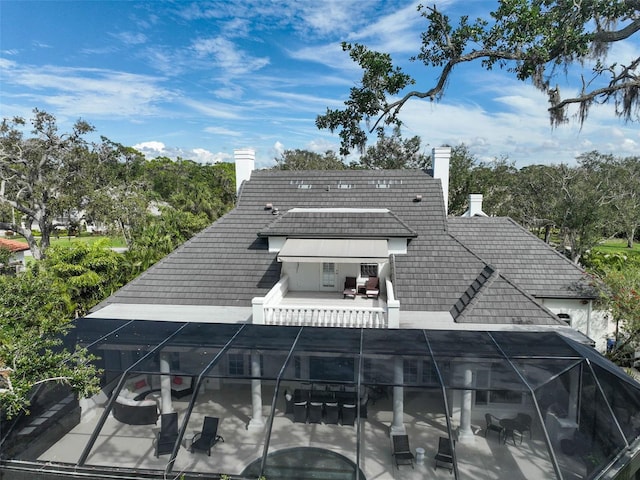 back of house with a patio, a lanai, and a chimney