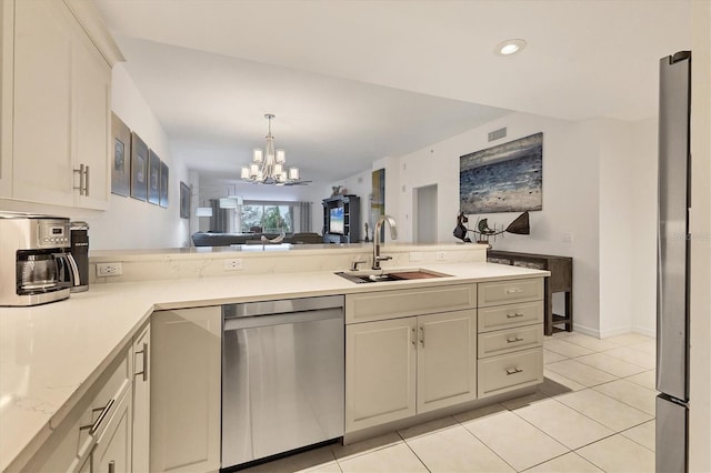 kitchen featuring a notable chandelier, kitchen peninsula, sink, stainless steel appliances, and light tile patterned floors